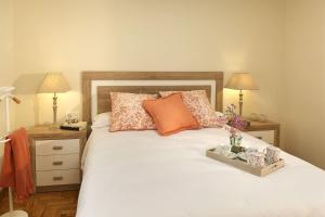 1 dormitorio con 1 cama blanca con almohadas y 2 lámparas en Apartamento Ravachol Pontevedra ciudad, en Pontevedra