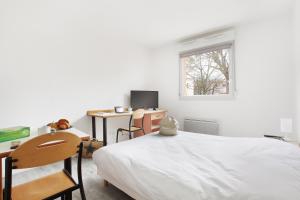 a bedroom with a bed and a desk and a window at Neoresid - Résidence Clos Morlot in Dijon