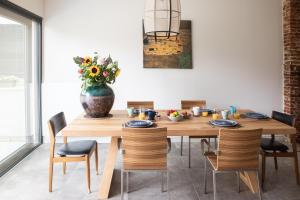 uma sala de jantar com uma mesa de madeira com um vaso de flores em Vakantiehuis Hana em Heers