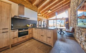 a kitchen with wooden cabinets and a stone wall at AlpenParks Hotel & Apartment Sonnleiten in Saalbach Hinterglemm