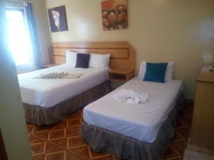 2 Betten in einem Hotelzimmer mit Handtüchern darauf in der Unterkunft Ntshe River Lodge in Francistown