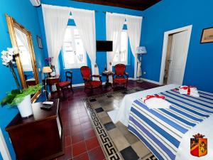 a blue room with a bed and a table and chairs at Palazzo Toraldo di Francia in Tropea