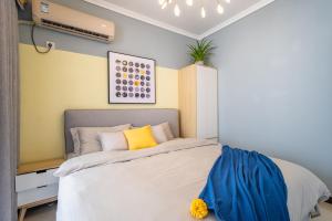 um quarto com uma cama com uma parede amarela em Zhengzhou Huiji·Province Sport Centre· Locals Apartment 00161400 em Zhengzhou