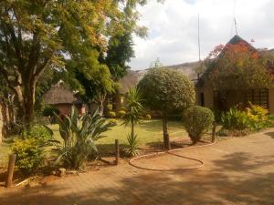 un jardin avec un panier de basket en face d'une maison dans l'établissement Ntshe River Lodge, à Francistown