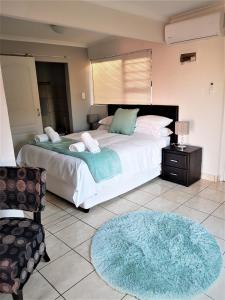 Un dormitorio con una cama grande y una alfombra azul en Comfey Stay, en Ciudad del Cabo