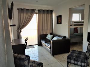 sala de estar con sofá y ventana en Comfey Stay, en Ciudad del Cabo