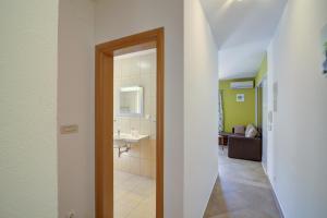 a hallway with a bathroom with a sink and a living room at Apartments Stipe in Lukovo +140 photos
