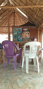 two purple and white chairs sitting in front of a table at Refúgio Raiz Camping in Carolina