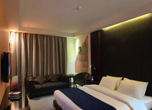 una habitación de hotel con una cama y un sofá en Torino Hotel Amman, en Amán