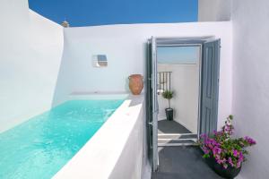 a swimming pool in the middle of a white house at Demeter Cave House - Luxury Adults Only Cave House in Pyrgos