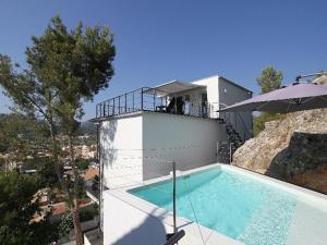 a house with a swimming pool and an umbrella at The one in Andratx