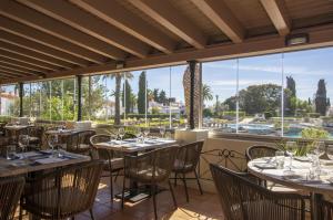 a restaurant with tables and chairs and a large window at Rocha Brava Village Resort in Carvoeiro +37 photos