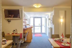 a living room with two tables and a dining room at Pension Torkel-Stube in Ingolstadt