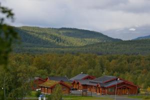 a group of wooden cabins in front of a mountain at Tunet in Hemavan