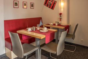 une salle à manger avec deux tables et des chaises dans l'établissement Pension Torkel-Stube, à Ingolstadt