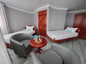 um quarto com duas camas, um sofá e uma mesa em Gold Beach Resort em Flic-en-Flac