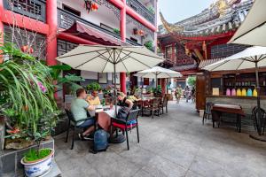a group of people sitting at a restaurant with umbrellas at Wenjun Courtyard Hotel ---5 mins walk from Tonghuimen metro station, near Tianfu square, close by culture park and Sichuan opera house, English speaking service, local tours in Chengdu
