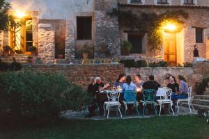 a group of people sitting at a table in front of a building at Agroturismo Can Torna AG178 in Esporles