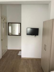 een kamer met een flatscreen-tv aan de muur bij Tay Pansiyon in Bodrum City