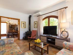 ein Wohnzimmer mit einem TV und einem Tisch in der Unterkunft Can miraet in Santa Margalida