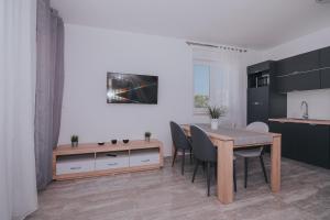 a kitchen and dining room with a table and chairs at Apartments Pool Villa Aldura in Novalja