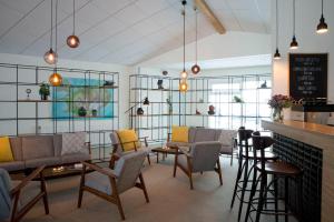a living room with chairs and tables and a bar at Hotel Gullfoss in Haukadalur