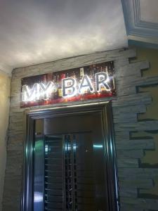 um sinal de néon por cima de uma porta para um novo bar em Hotel Lilo near Airport em Tbilisi