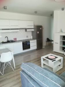 eine Küche und ein Wohnzimmer mit einem Sofa und einem Tisch in der Unterkunft Centrum Haus in Giżycko