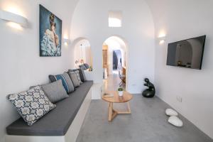 a living room with a couch and a table at Demeter Cave House - Luxury Adults Only Cave House in Pyrgos