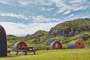 a group of three domes and a picnic table in front of a mountain at Iona Pods in Iona