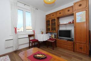 a living room with a table and a tv at Apartment Dina in Rovinj
