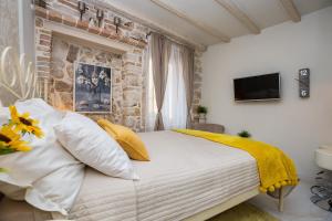 een slaapkamer met een bed met een gele deken erop bij Studio Yellow Flower in Rovinj