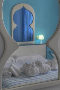 una camera da letto con un letto con uno specchio sopra di Hotel Arabesque a Varigotti