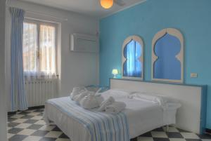 Un dormitorio azul con una cama con toallas. en Hotel Arabesque, en Varigotti