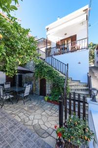 a patio with a table and stairs to a house at Eleni Studios Neo Klima Skopelos in Skopelos Town
