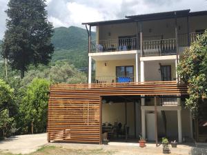 a large house with a large balcony on top of it at Guest house LETTO in Gagra