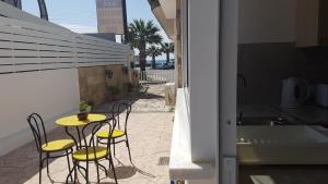 een gele tafel en stoelen op een patio met een wastafel bij ZORBAS No 2 in Larnaka