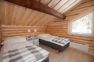 1 dormitorio con 2 camas en una cabaña de madera en Timmervillan, en Funäsdalen