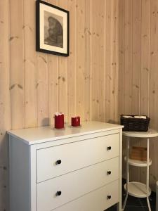 a white dresser with two red candles on top at Kvamseter Lodge in Kvamseter