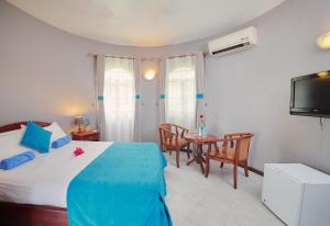 sypialnia z łóżkiem, stołem i telewizorem w obiekcie Gold Beach Resort w mieście Flic-en-Flac