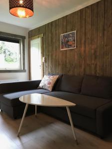 sala de estar con sofá negro y mesa en Kvamseter Lodge, en Kvamseter
