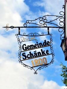 Landhotel Gemeindeschänke في Wanfried: علامة تدل على علامة الصوديومامين الكريمة على المبنى