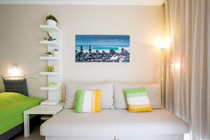 una piccola camera da letto con un letto bianco con cuscini colorati di Cozy apartment in Edificio Bahamas a Puerto de la Cruz