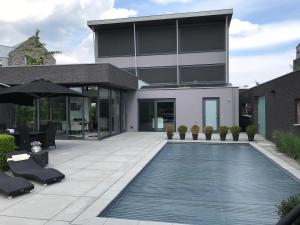 a house with a swimming pool in front of a building at WK12 Suite in Cuijk