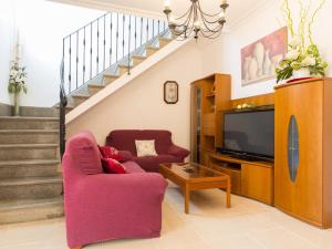sala de estar con sofá, TV y escaleras en Villa marimar, en Muro