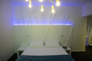 a bed in a room with lights above it at Sunrise Rooms in Grado