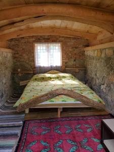a large bed in an attic room with a window at Eco Camp Dzogaska Vrela in Pljevlja