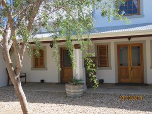 ein Haus mit einem Baum davor in der Unterkunft Karoo-Rust in Prince Albert