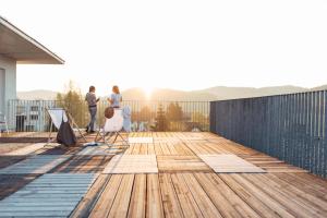 a deck with two people standing on a house at harry's home hotel & apartments in Graz