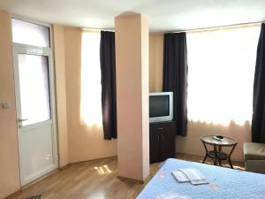 mały pokój z łóżkiem i telewizorem w obiekcie МОТЕЛ СИТИ w Płowdiwie